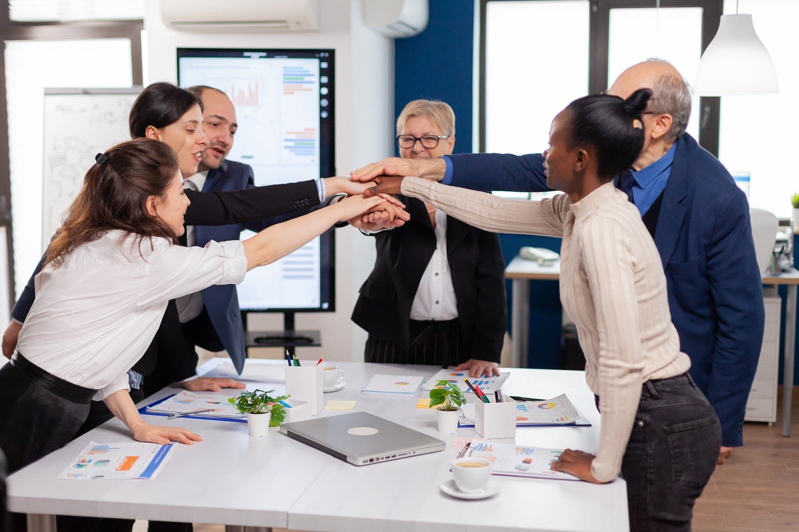 Leadership team joining hands in a huddle