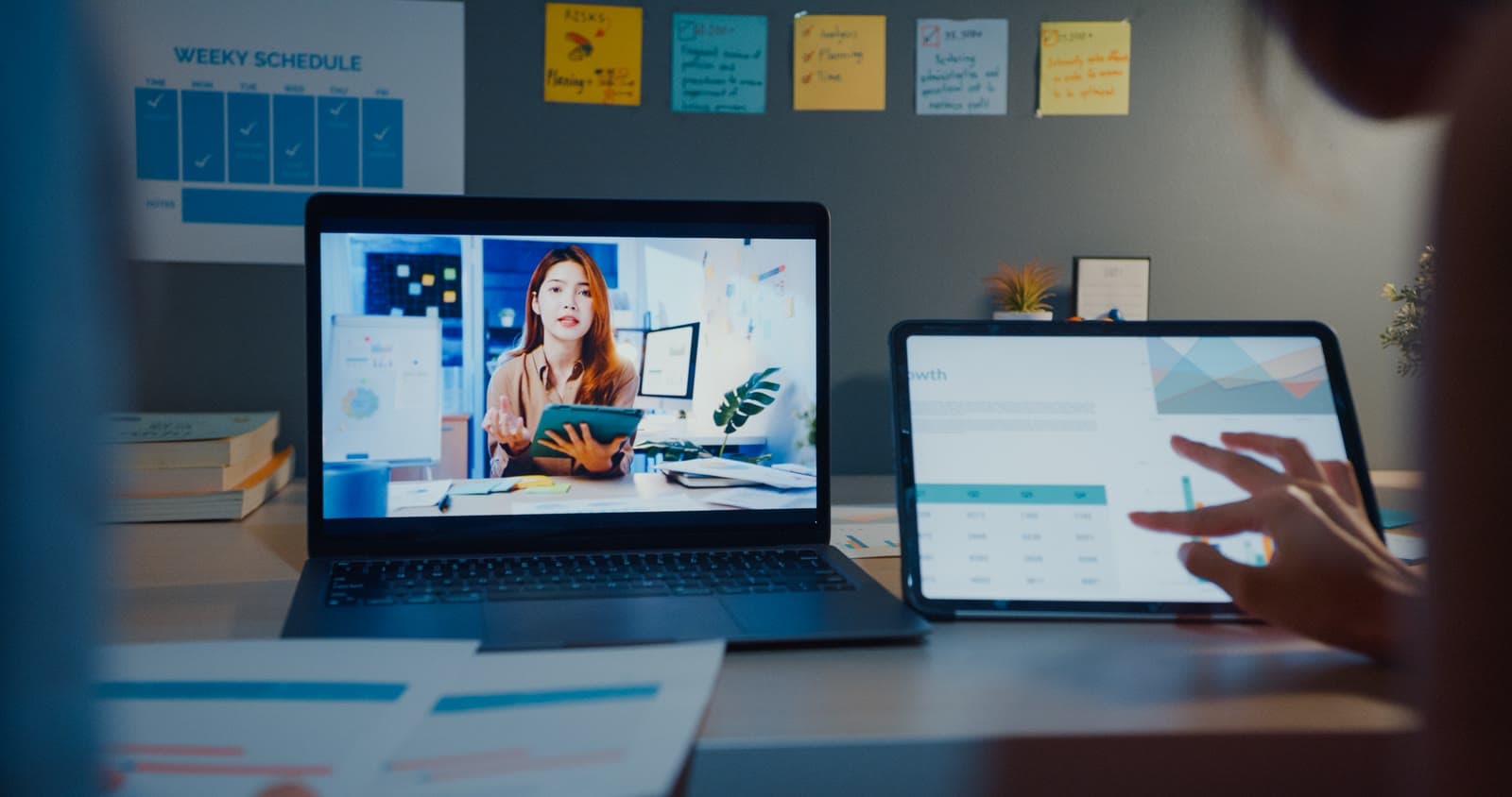 A learner joining an online lesson on a laptop with a tablet dashboard alongside