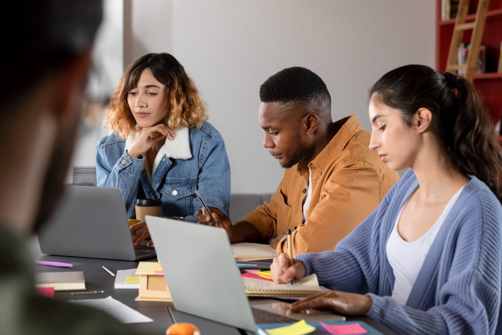 A small team collaborating around laptops on a course